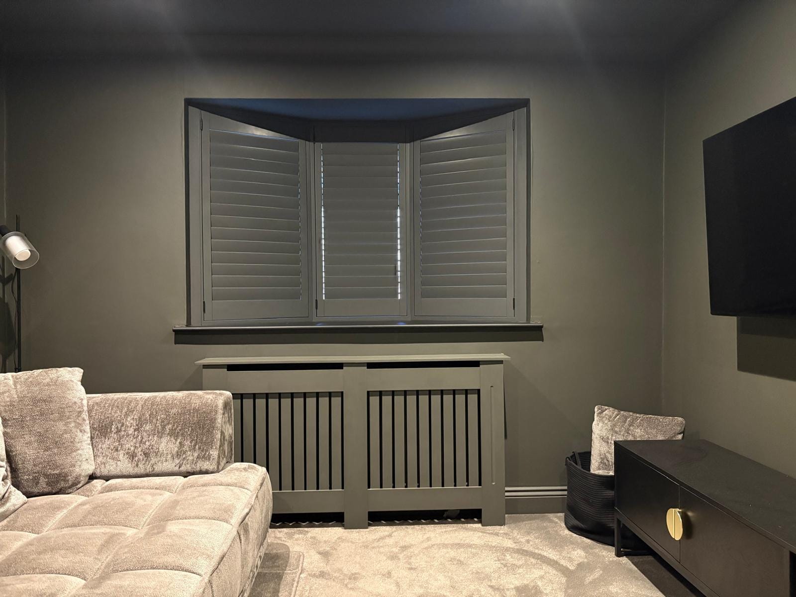 Dark grey plantation shutters installed in a contemporary Essex home cinema, providing privacy and light control