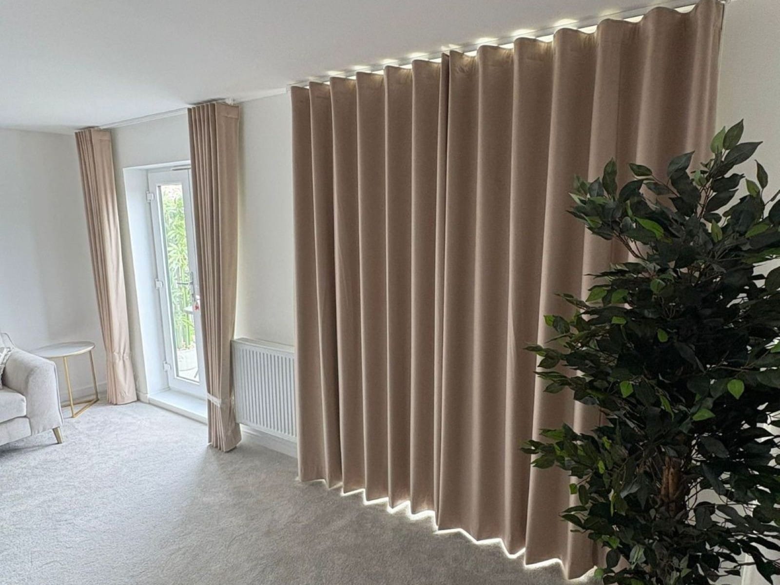 Made to measure wave curtains in soft beige fabric, fitted across patio doors in a modern Essex living room.
