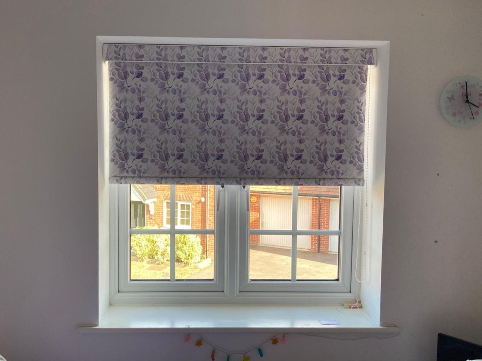 Made-to-measure patterned roller blind in soft lilac tones, part of the Anycolour range from John’s Blinds & Curtains in Essex.