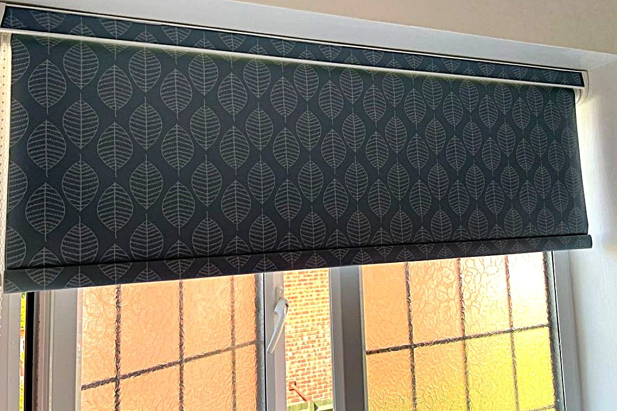 Patterned PVC cassette roller blind fitted above a frosted bathroom window, providing privacy and moisture resistance.