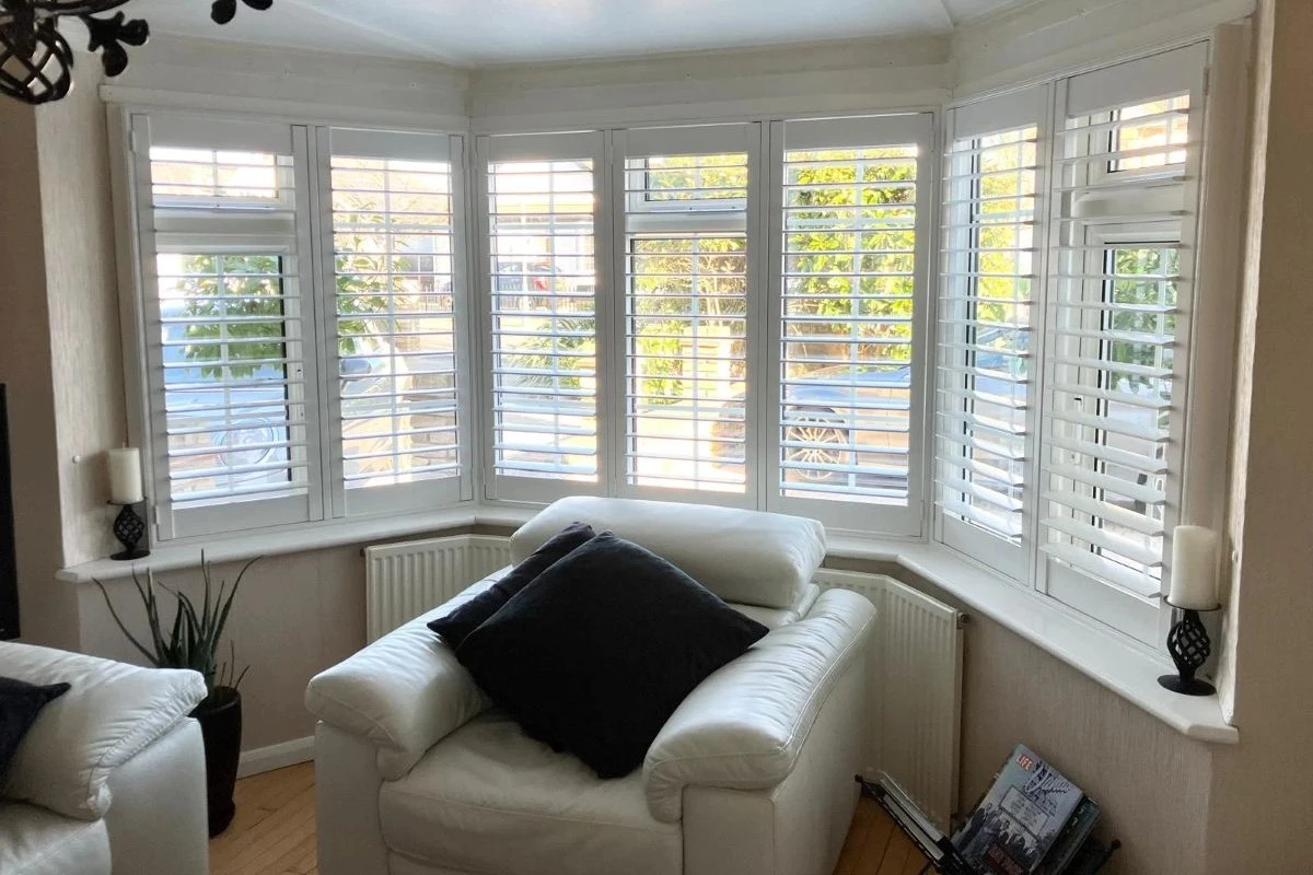 Plantation shutters fitted to a living room bay window