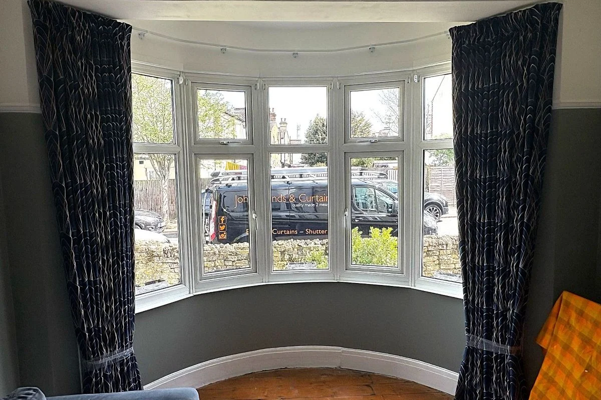 Bedroom Pencil Pleat Curtains – Delaunay Sapphire Pencil pleat bedroom curtains in Delaunay Sapphire fabric fitted to a bay window