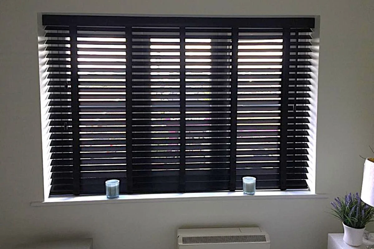 Black Wooden Venetian Blinds with Tapes in Bedroom Black wooden Venetian blinds with decorative tapes fitted to a bedroom window.