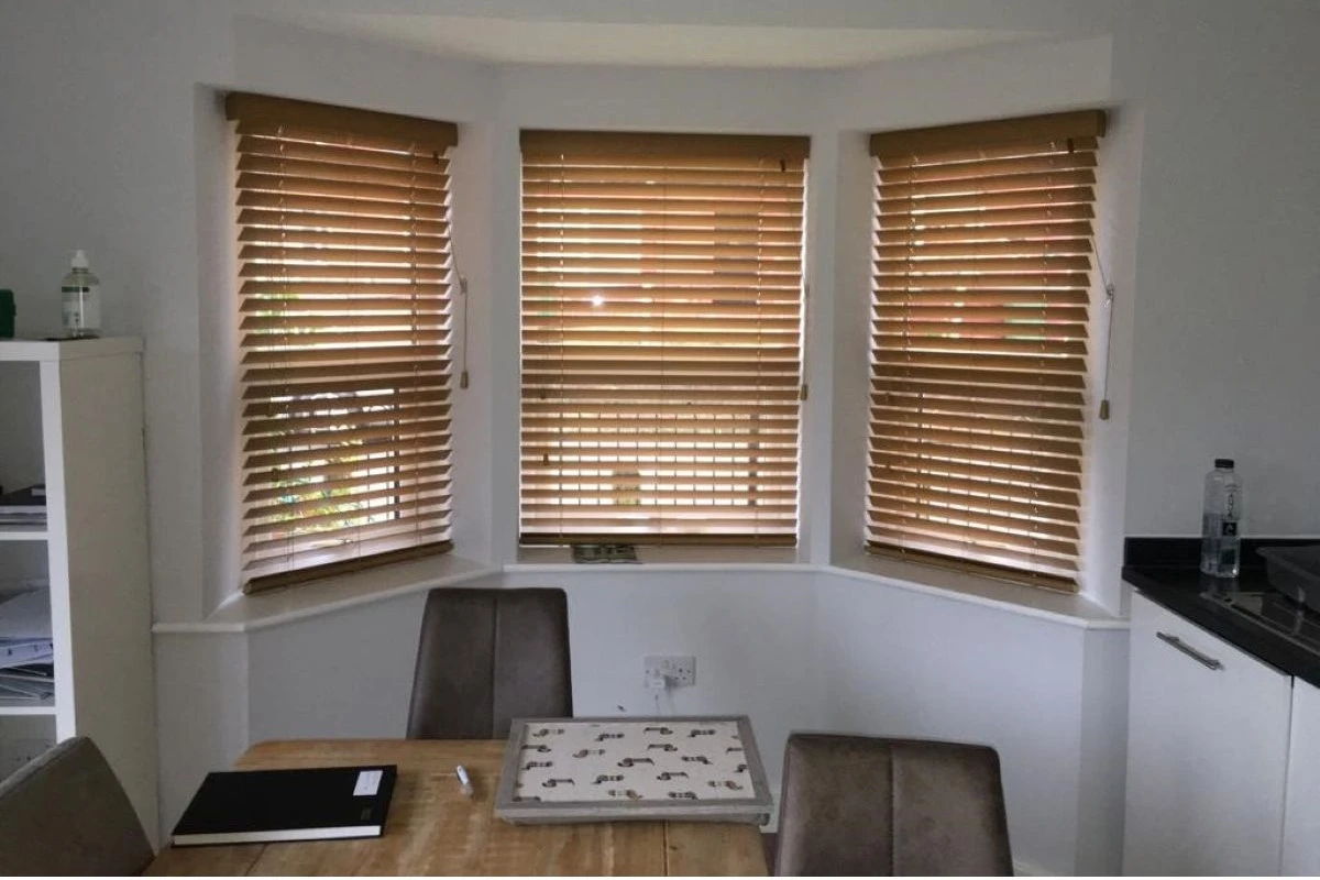Faux Wood Venetian Blinds in a Kitchen–Dining Area (Bay Window) Faux Wood Venetian blinds fitted to a kitchen–dining bay window, providing adjustable light control.