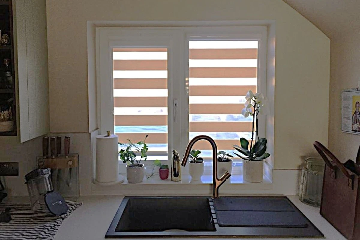 Perfect Fit Day & Night Blind on Kitchen Sink Window Perfect Fit Day and Night blind fitted on a kitchen sink window with plants on the ledge