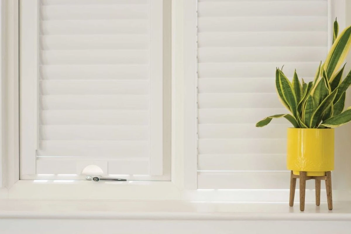 Perfect Fit Shutter Lite in Window Recess White Perfect Fit Shutter Lite blinds fitted neatly inside a window recess with a plant on the ledge