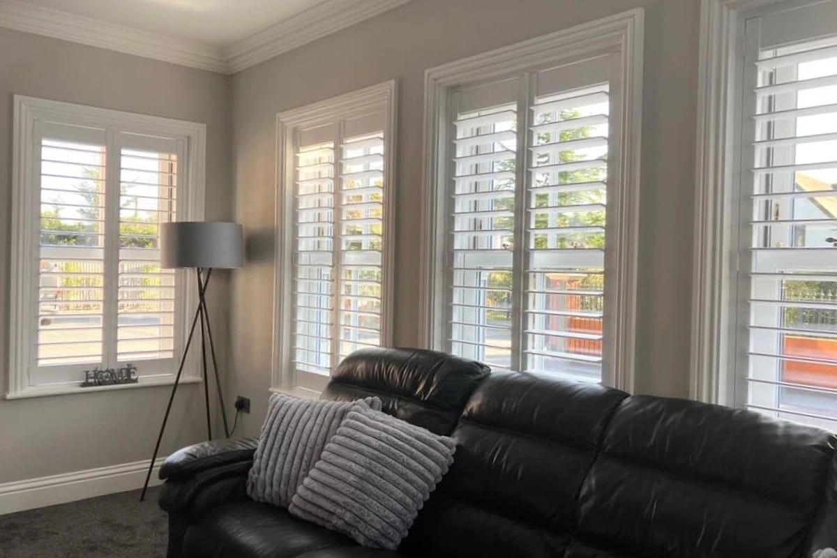 Full height plantation shutters installed on living room windows