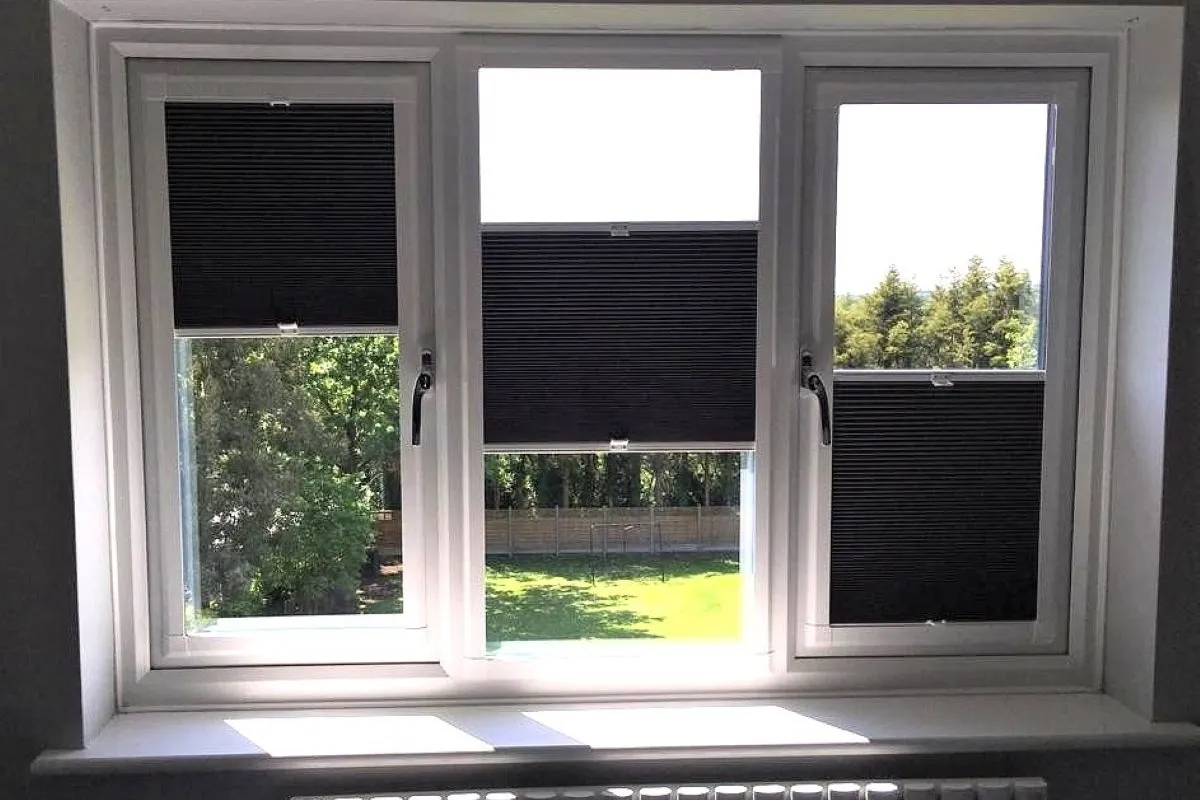 Multi-zone blackout cellular blinds fitted to a uPVC bedroom window, showing adjustable top and bottom sections.