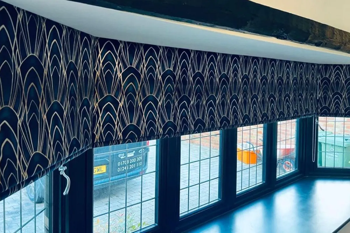 Roman blinds in Delaunay Sapphire fabric with an Art Deco pattern fitted across a wide bay window.