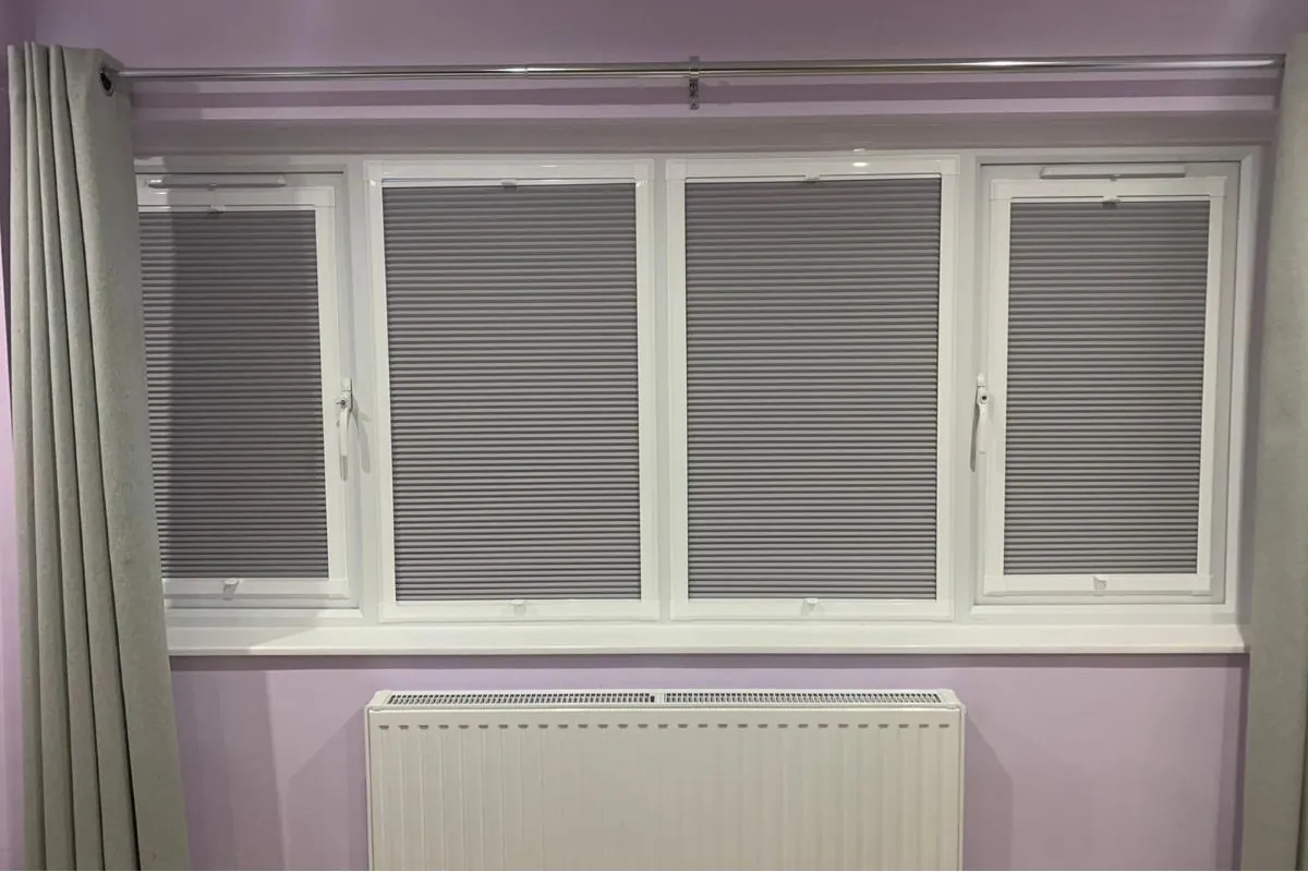 Perfect Fit Cellular Blinds Installed in a Bedroom Window Perfect Fit blackout cellular blinds fitted to a four-pane uPVC bedroom window with curtains.