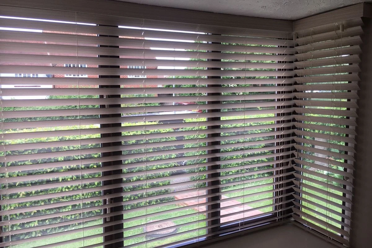 PVC 50mm venetian blinds installed in a square bay window, providing modern light control and privacy.
