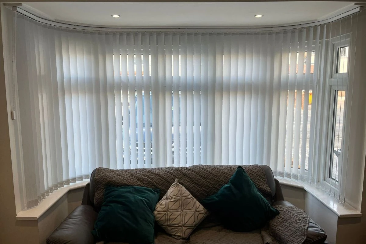 Vertical cascade louvres by Louvolite fitted in a curved bay window, creating a soft and elegant finish with great light control.