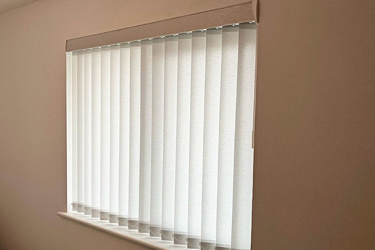 White vertical blinds with a matching fascia fitted to a bedroom window.