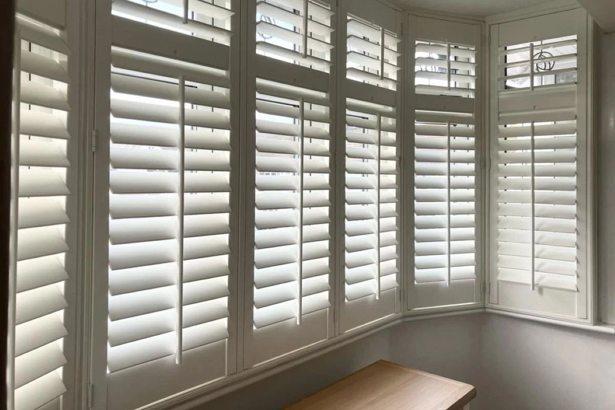 White plantation shutters installed in a bay window providing light control and privacy
