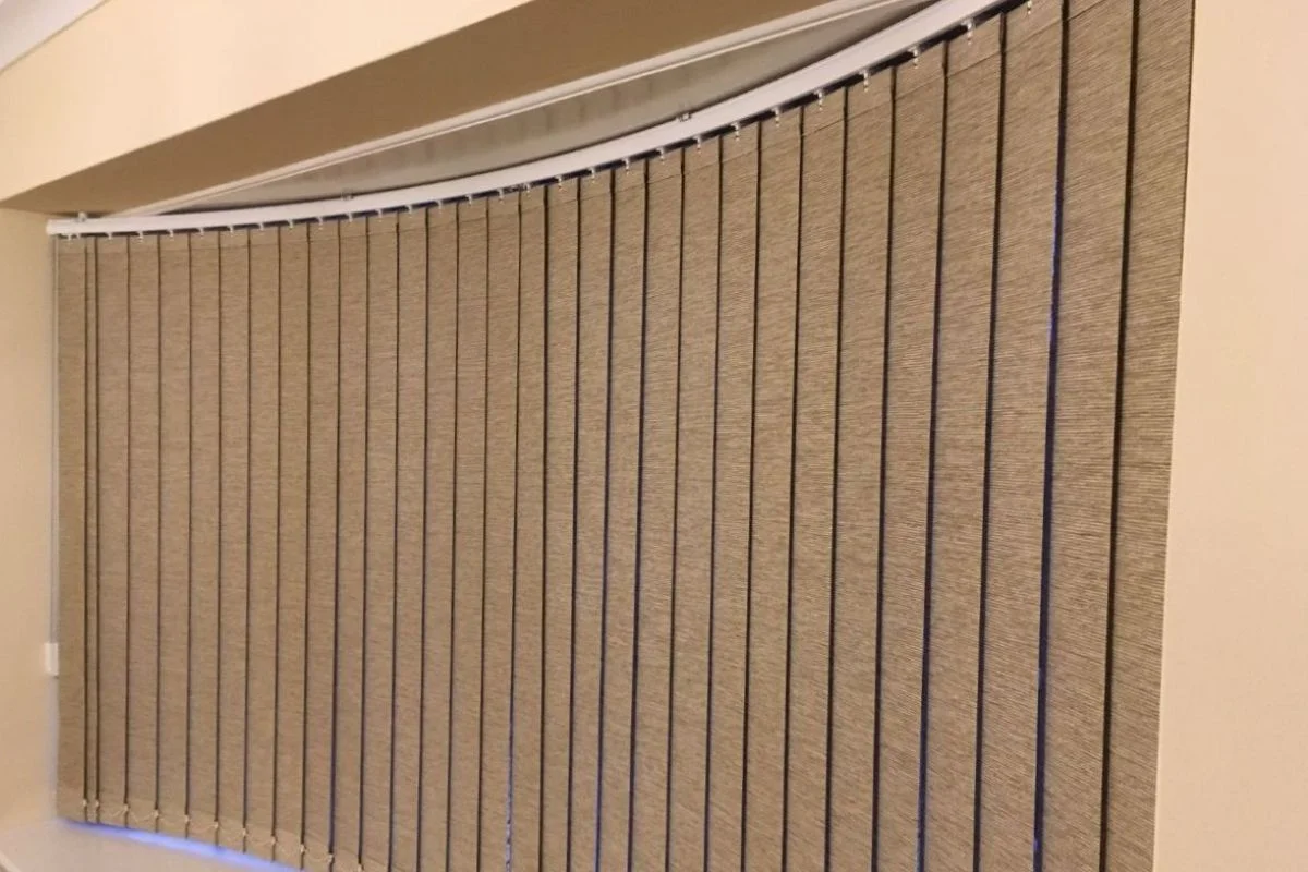 Made-to-measure vertical blinds fitted to a curved bay window, offering adjustable light control and privacy in a living room