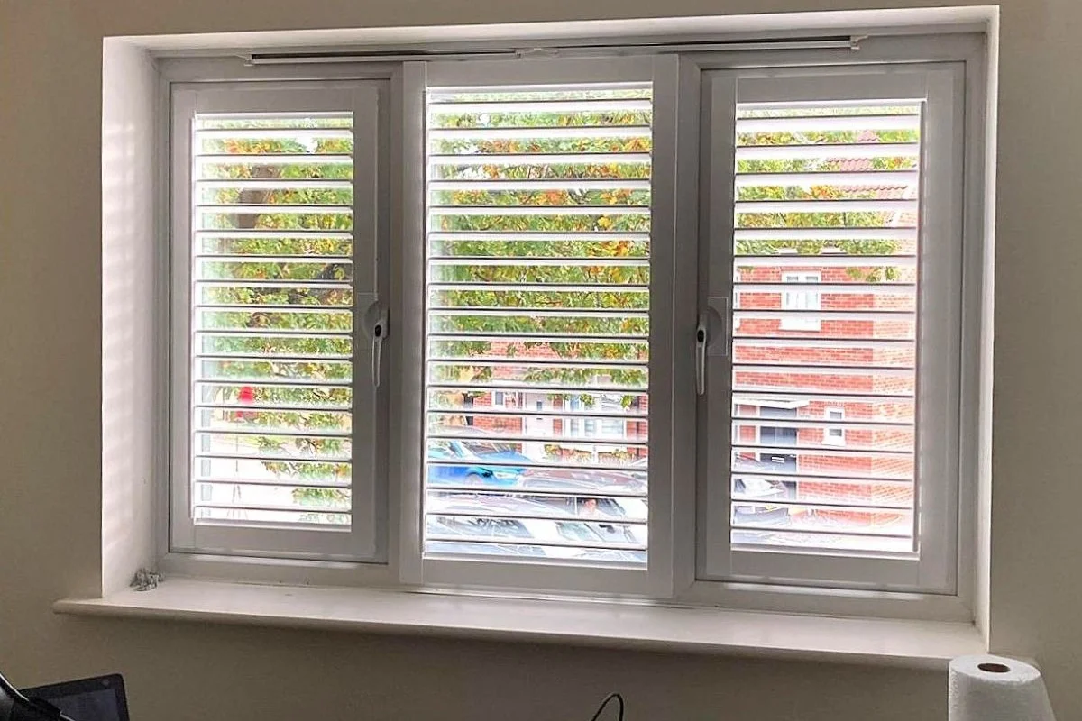 Perfect Fit shutters fitted within a uPVC window in a home office