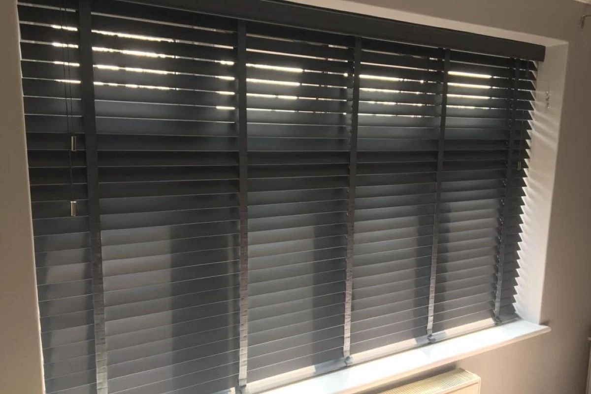 Grey Venetian blinds providing adjustable light control in a home office