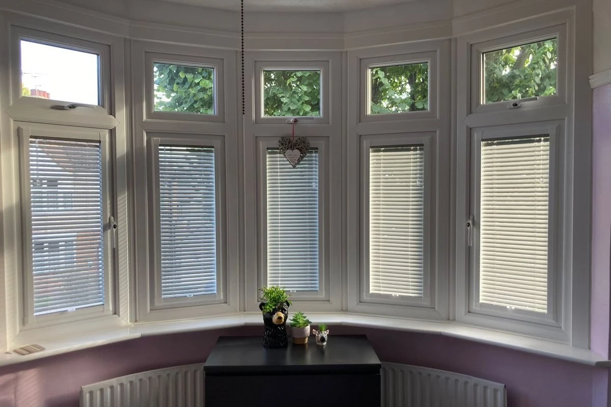 Perfect Fit aluminium Venetian blinds fitted to uPVC bay windows, providing neat light control without drilling