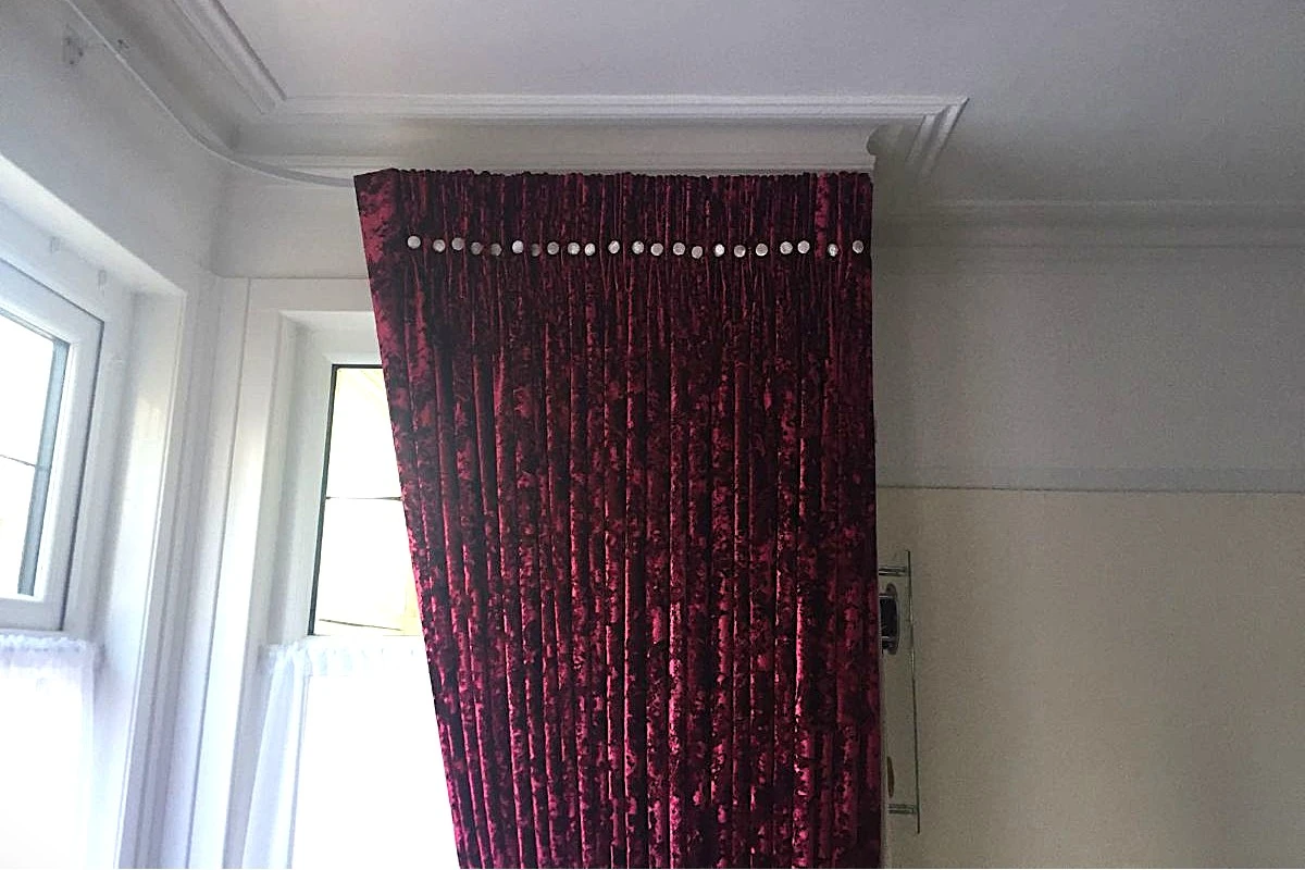 Pinch pleat curtains with decorative button detailing fitted to a bay window