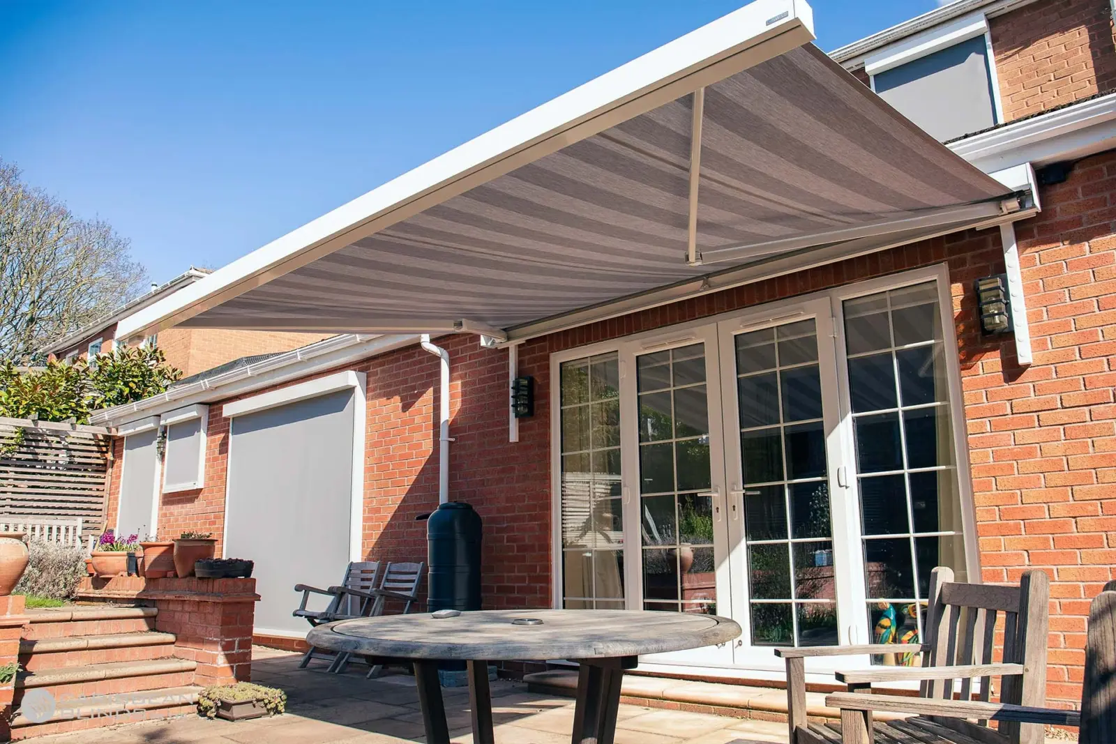 Motorised Cuba patio awning providing deep projection over French doors and patio
