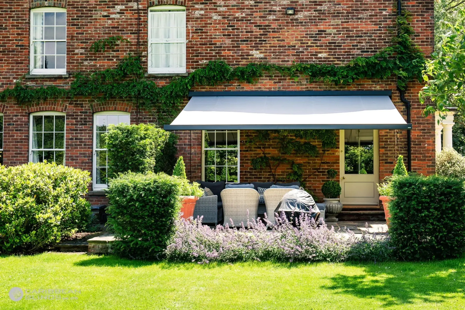 Anthracite grey Cuba full cassette patio awning installed on traditional brick home