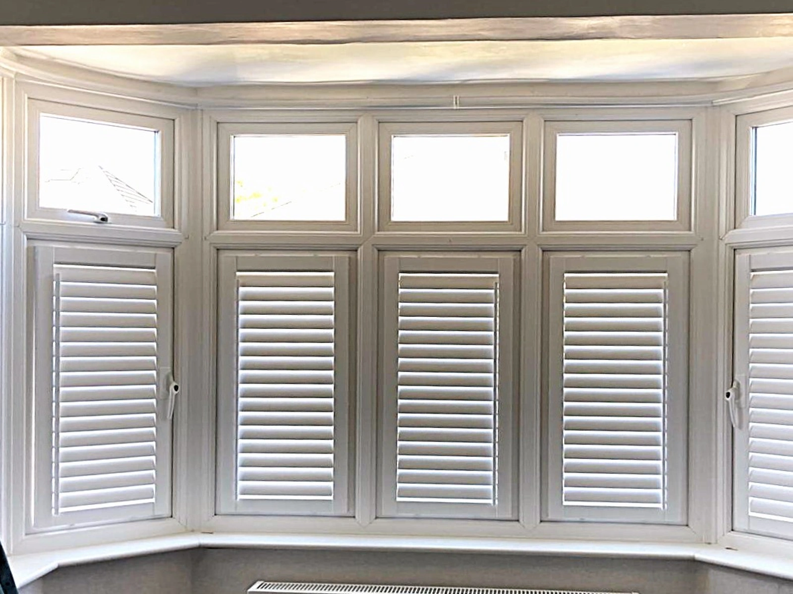 Perfect Fit Shutter Lite fitted to white uPVC bay windows without drilling
