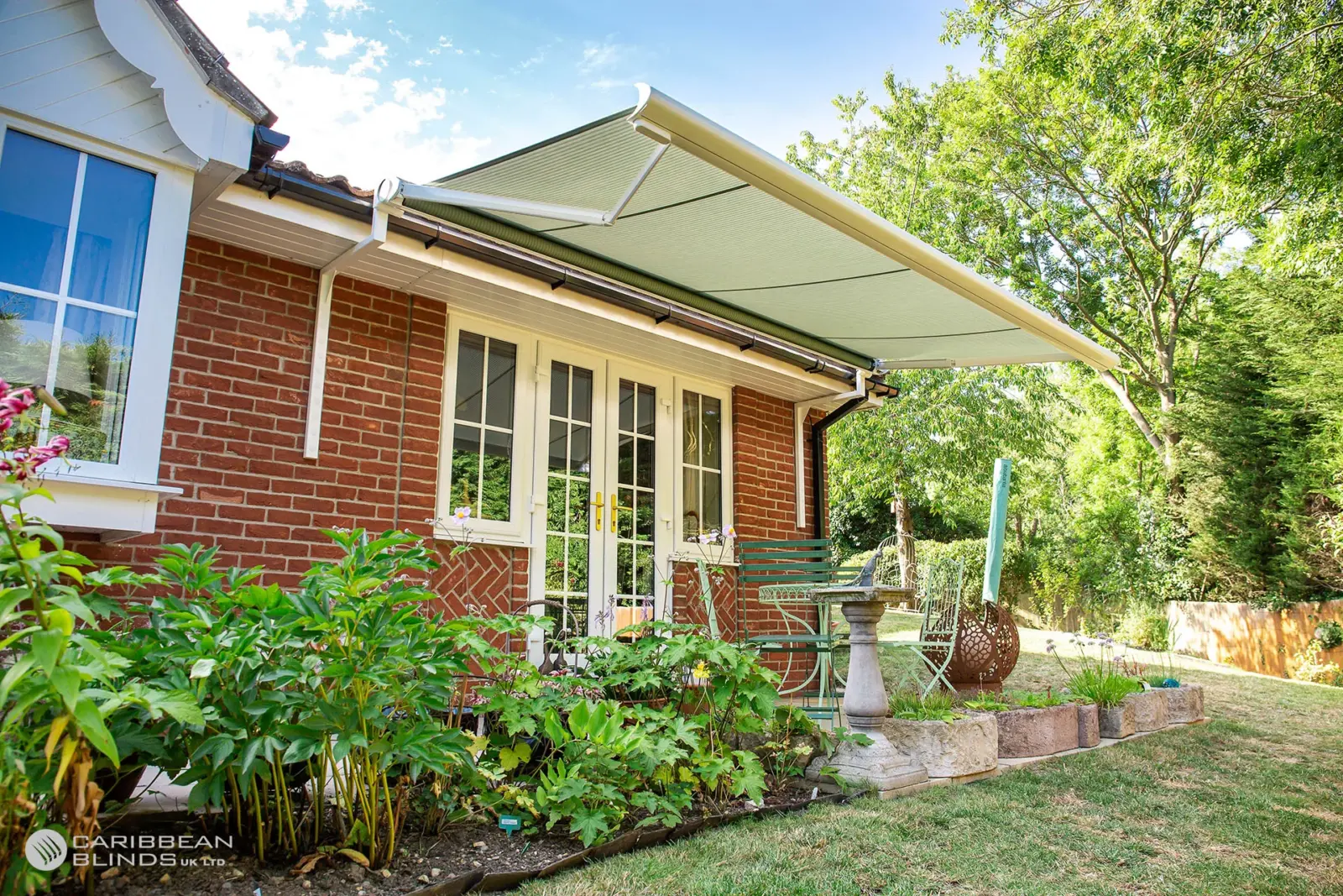 Anguilla patio awning installed on a red brick bungalow in Essex, providing shade over garden seating area