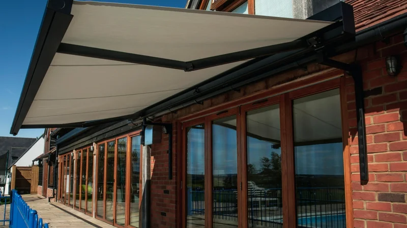 Black cassette Cuba patio awning installed on a modern brick property