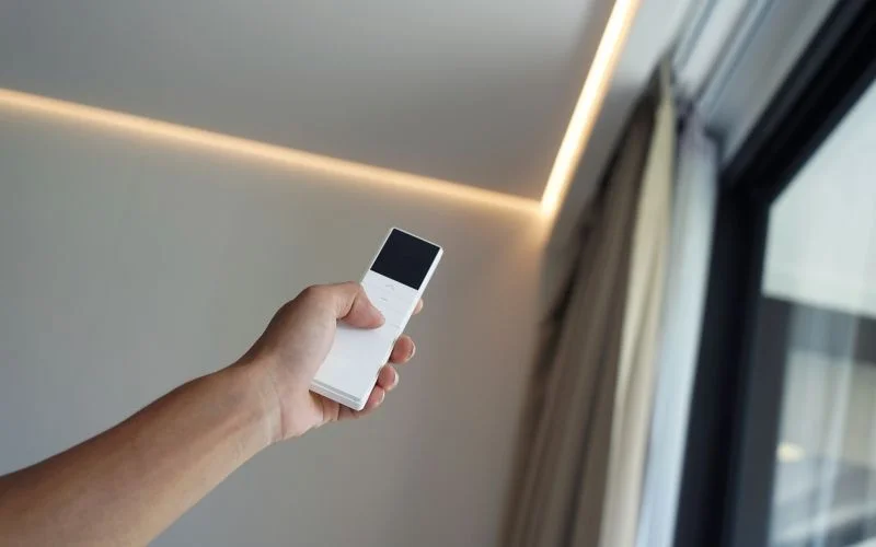 Smart automated curtain system being controlled with a handheld remote in a modern home setting