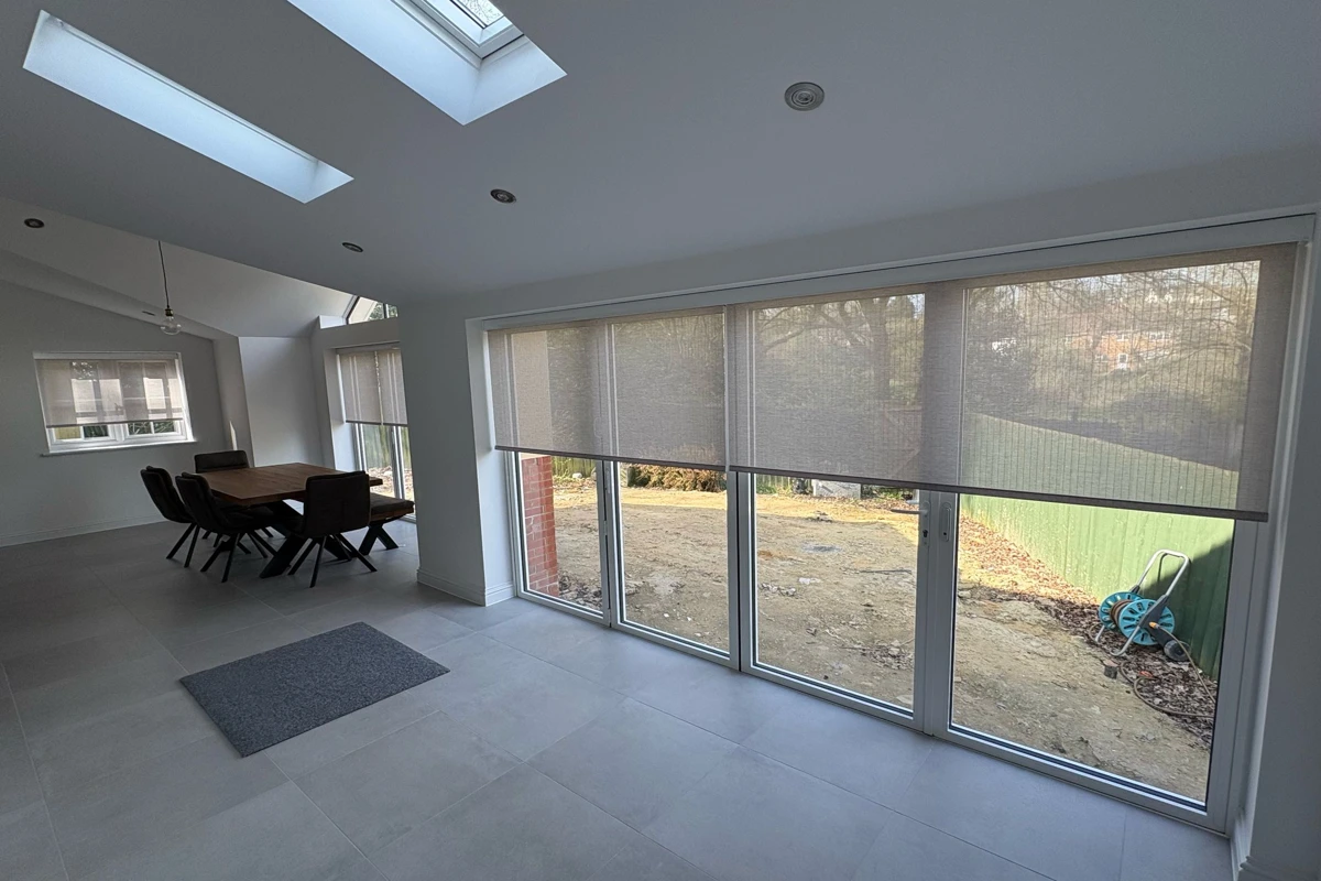 Automated roller blinds installed above bifold doors, inside the recess