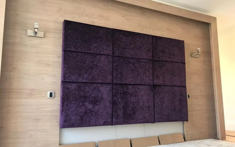 Custom purple padded wall panels installed in a modern bedroom interior