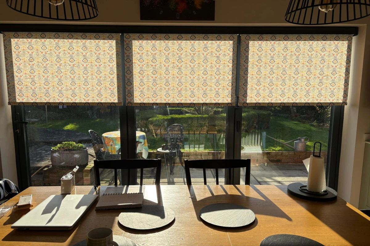 patterned roller blinds installed above bifold doors, inside the recess