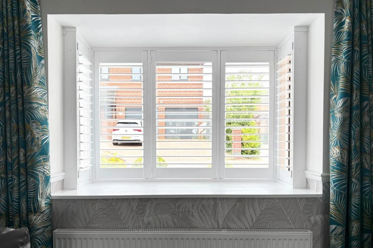 White plantation shutters controlling bright spring and summer daylight in a modern home