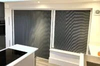Blackout blind screens fitted to windows, reducing light and improving room light control