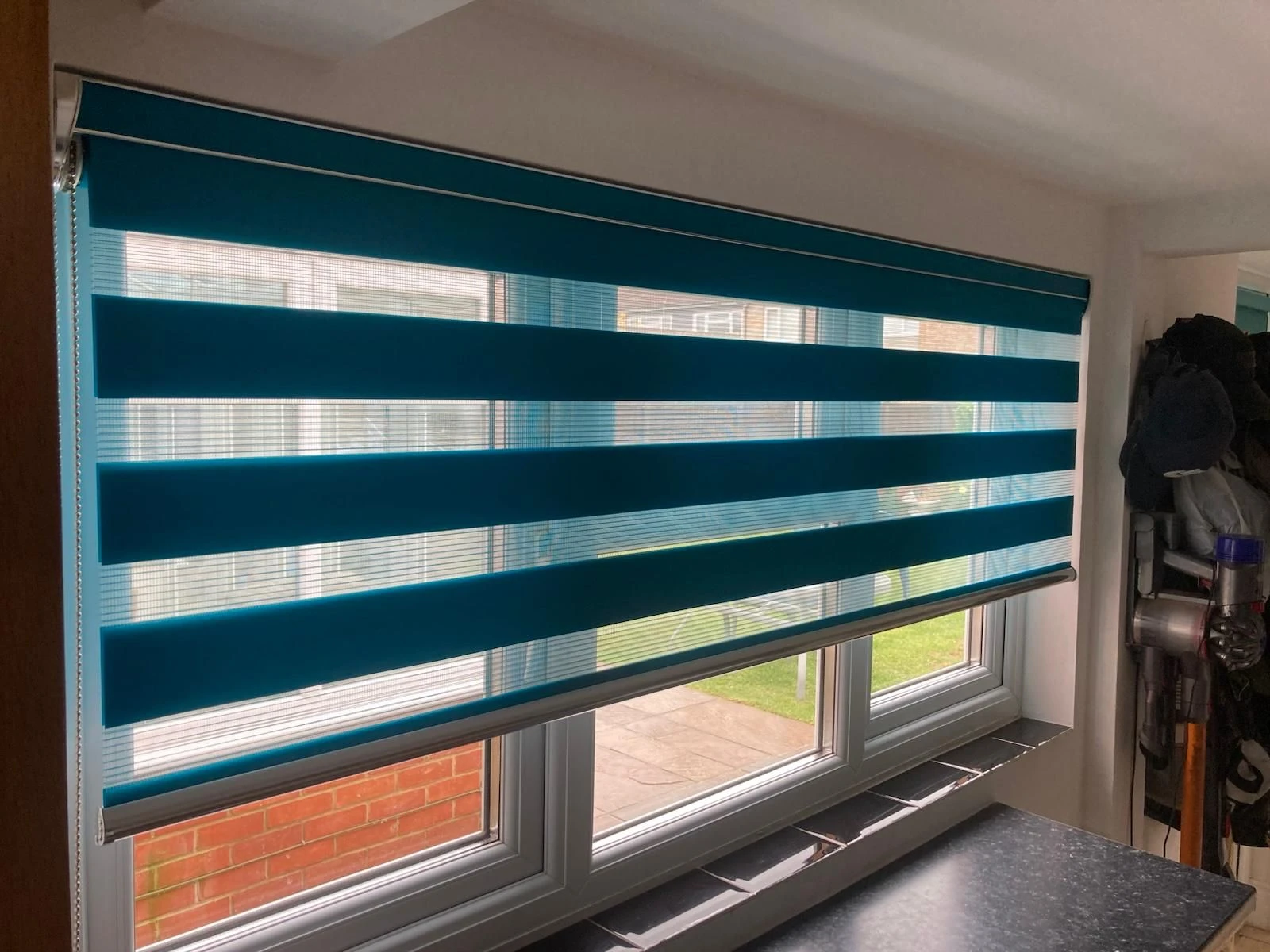 Soft Filtered Daylight with Day & Night blinds Turquoise Day & Night blind fitted to a modern kitchen window with layered light filtering fabric design.