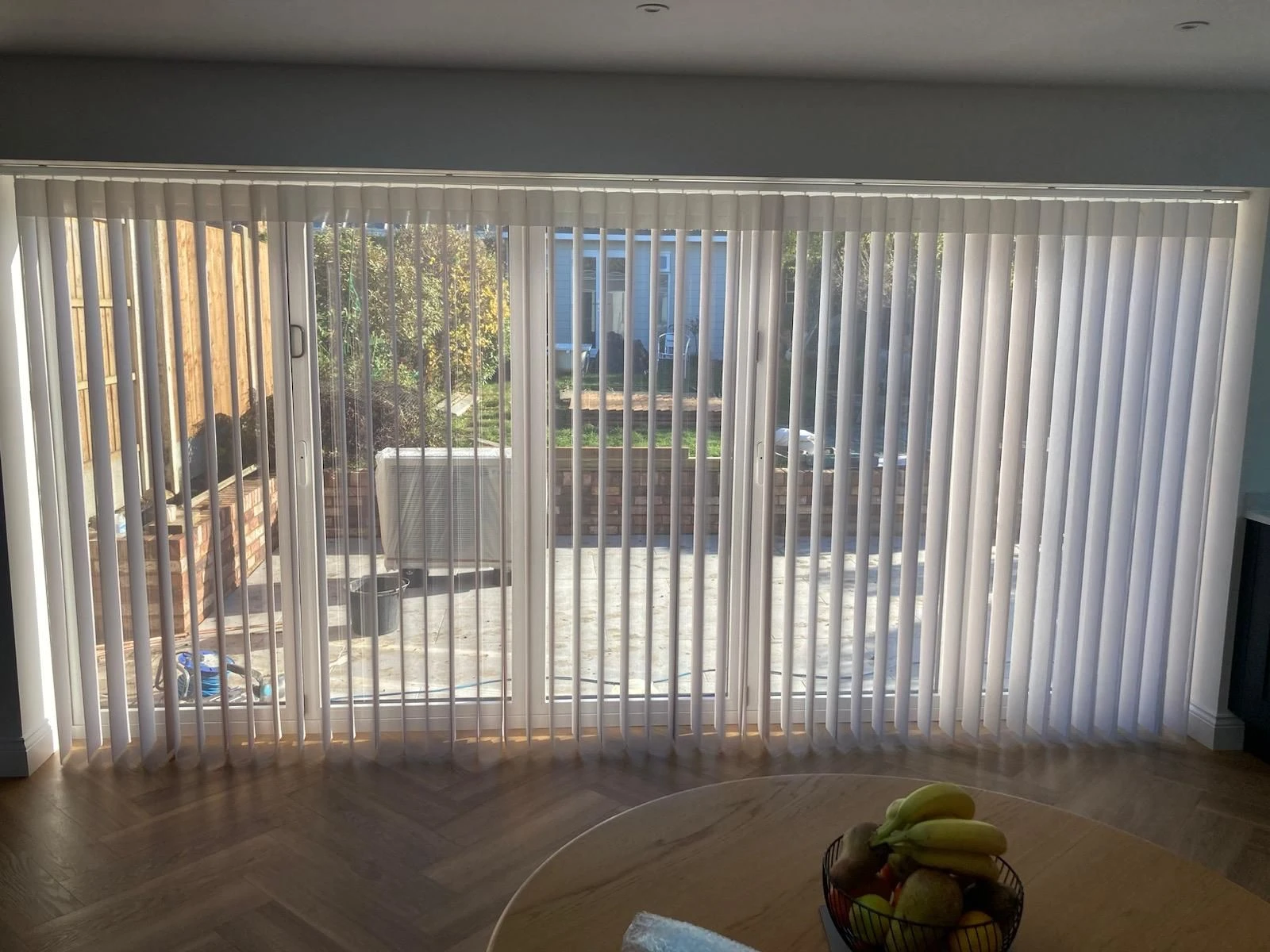Allusion Blinds for Open-Plan Living White Allusion blinds installed across large glazed doors in a modern open-plan kitchen and living area.