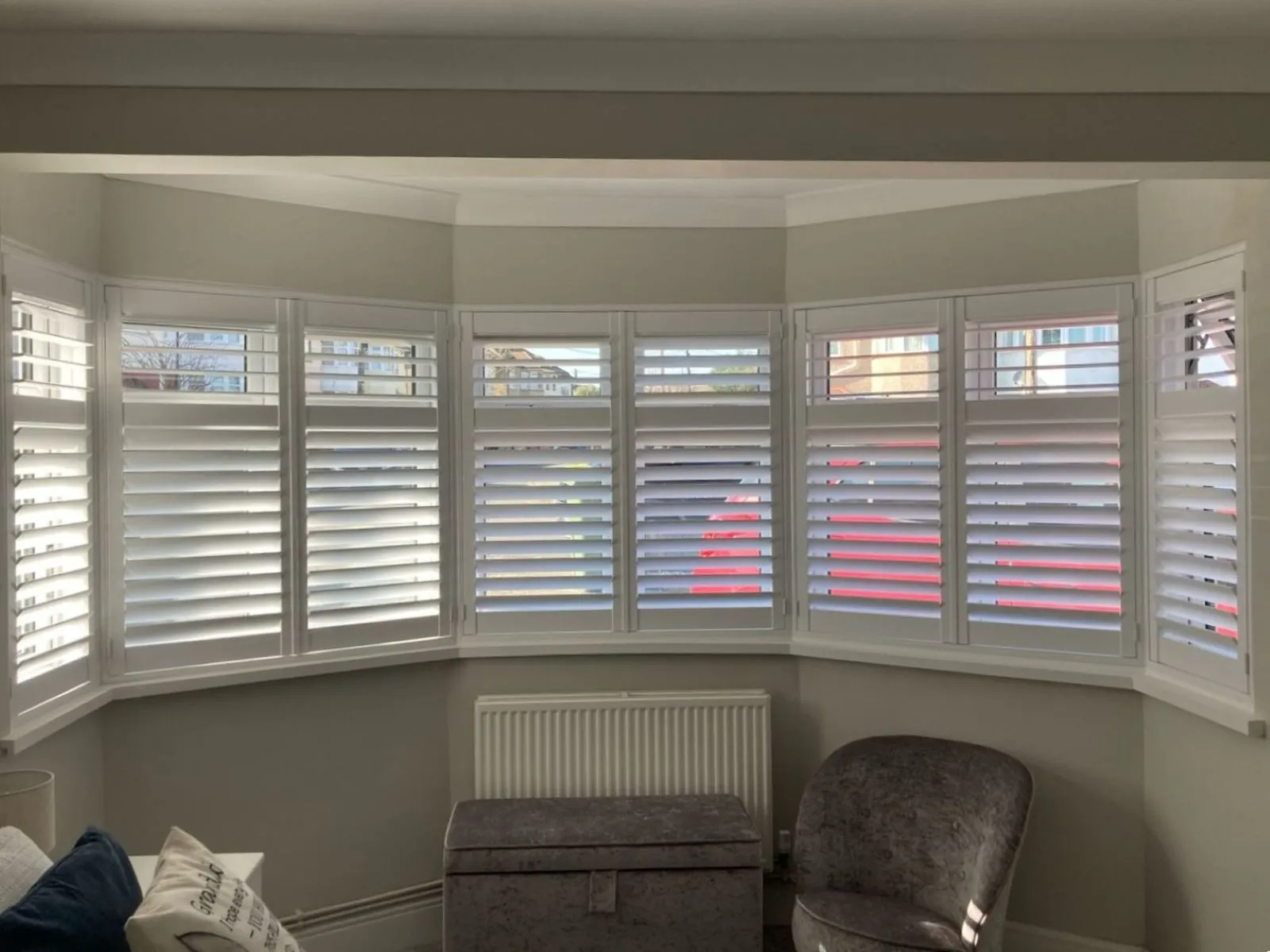 Plantation shutters fitted to a bay window with adjustable louvres, providing light control and privacy with a made-to-measure fit