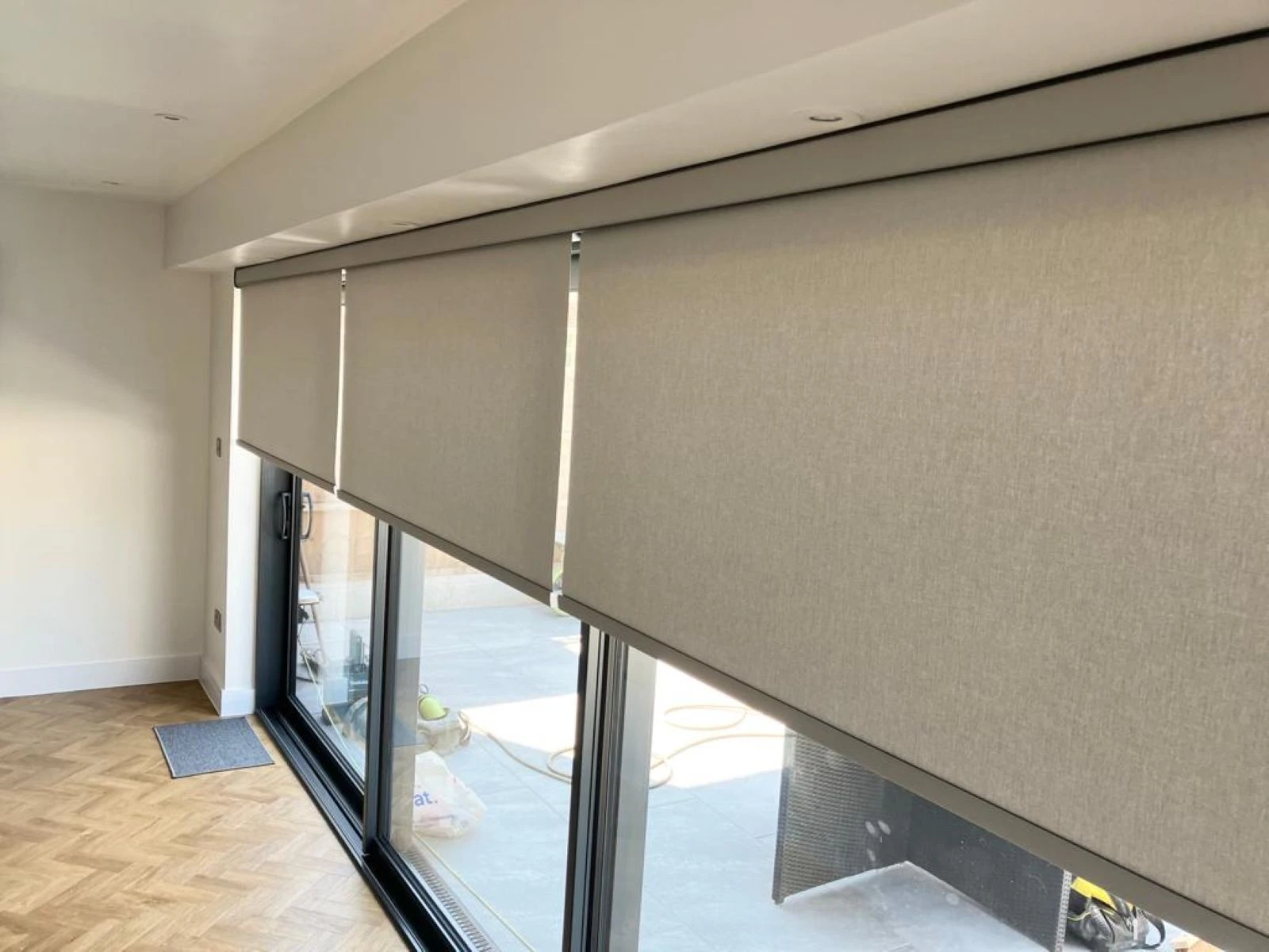 Modern Roller Blinds fitted across large glazed doors in a contemporary home interior.