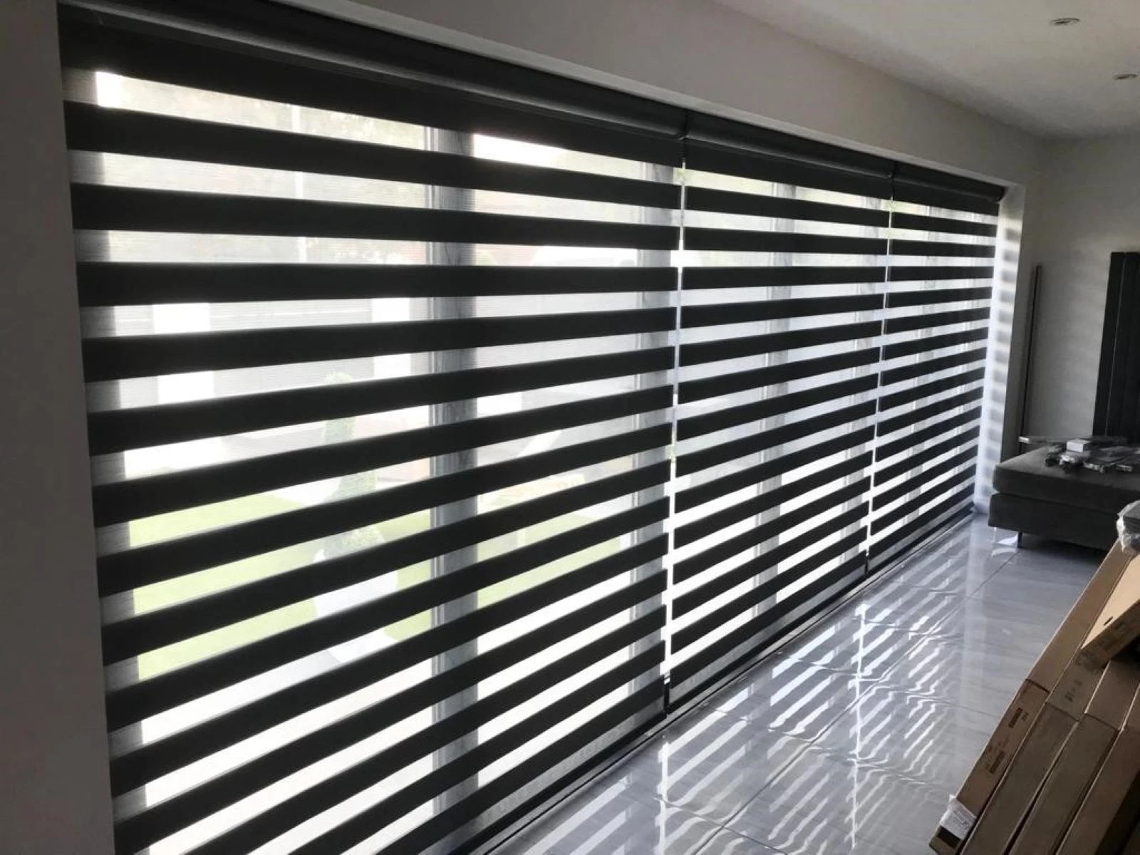 Day & Night Blinds for Large Windows Black Day & Night blinds installed across large modern windows in a contemporary open-plan living space.