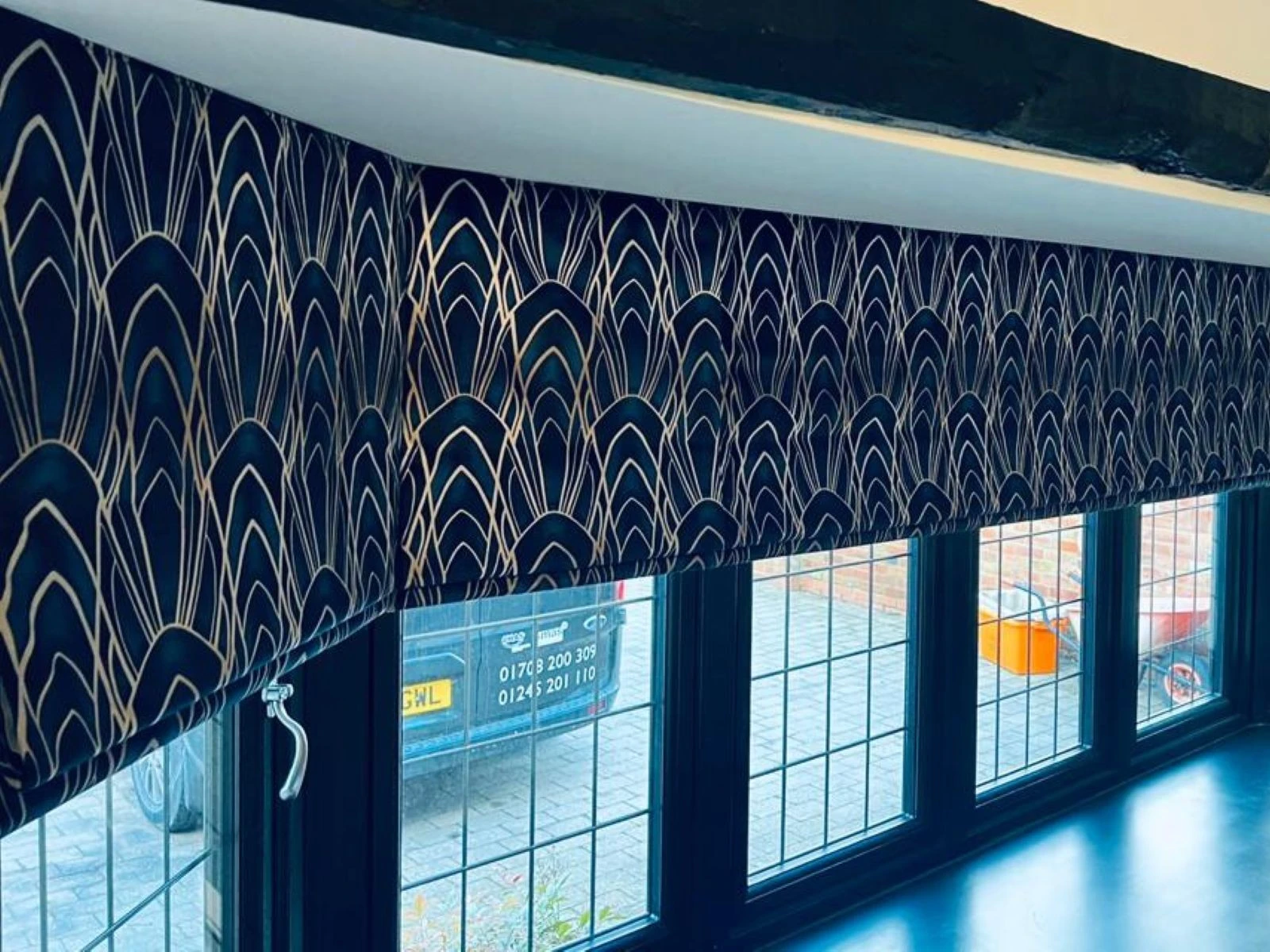 Blue patterned Roman blind installed within a contemporary interior space.