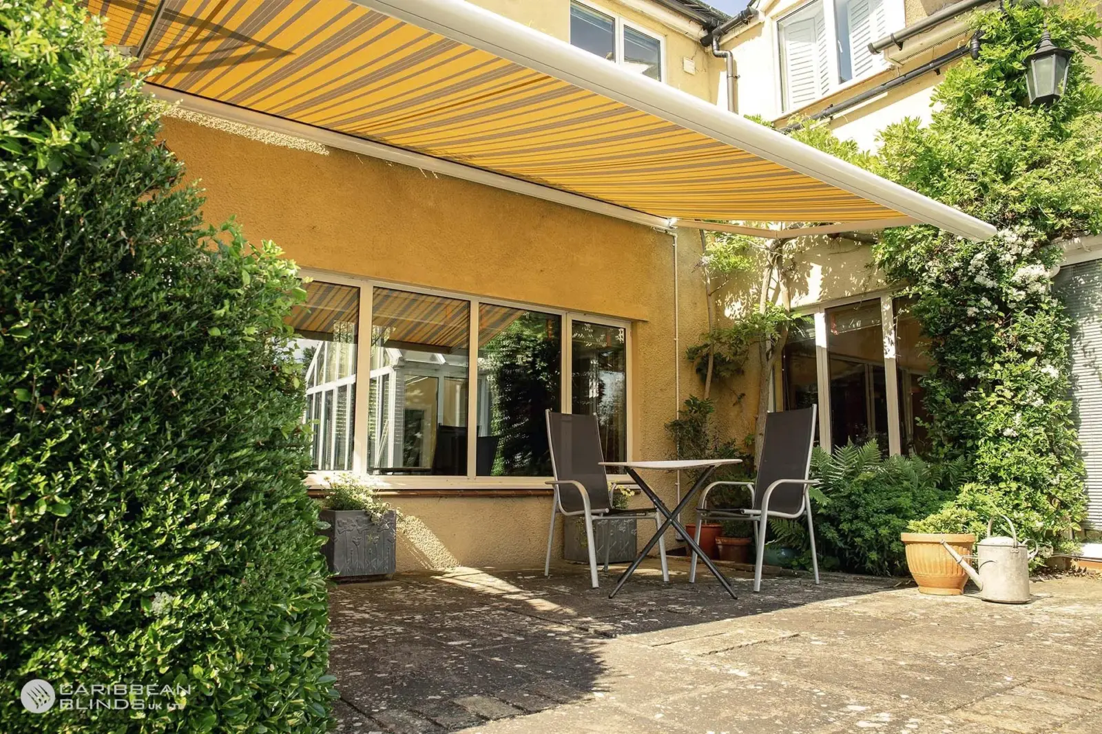 Retractable patio awning shading small garden seating area at Essex home