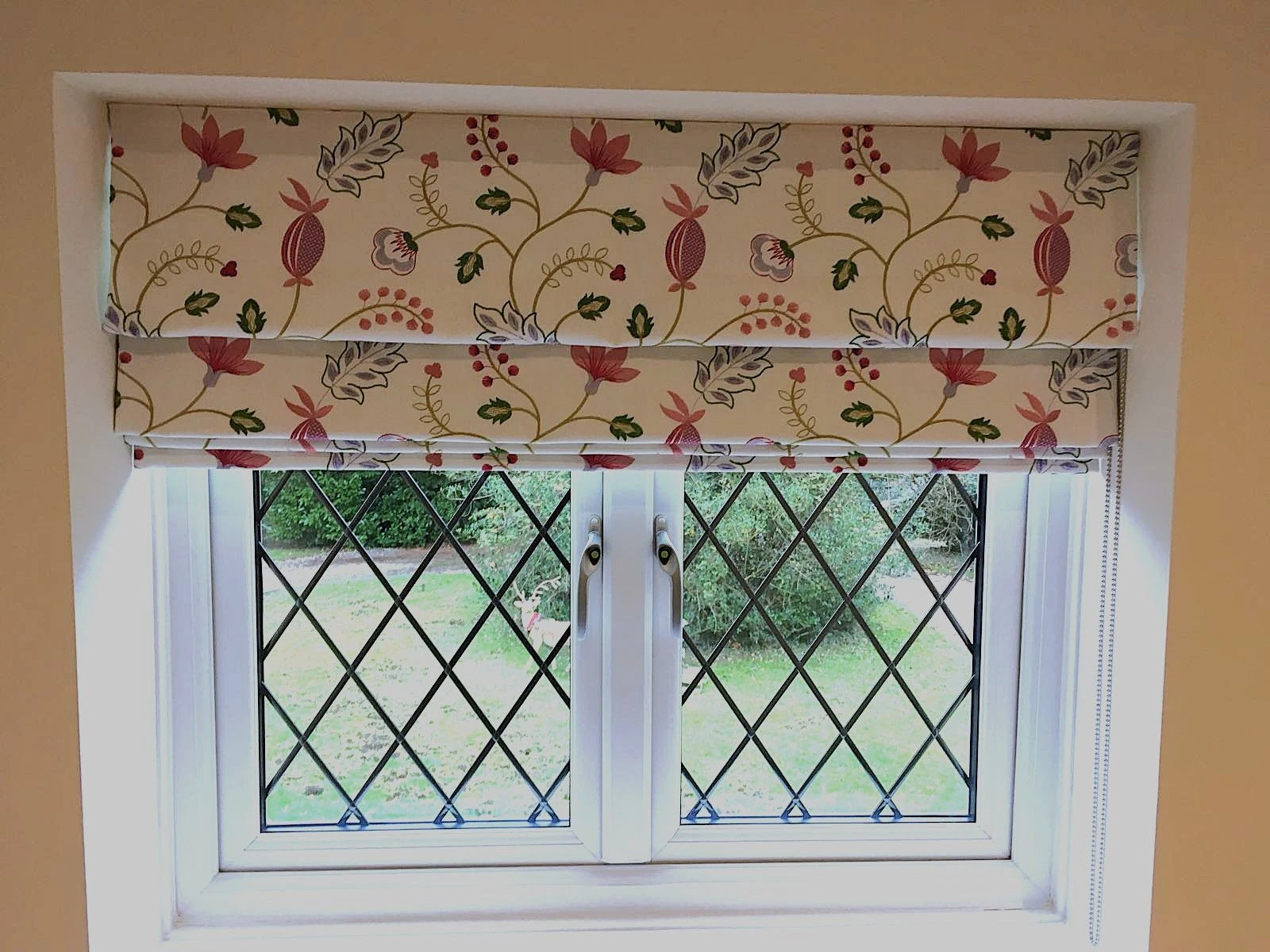 Patterned floral Roman blind fitted within a traditional style window in an Essex home.