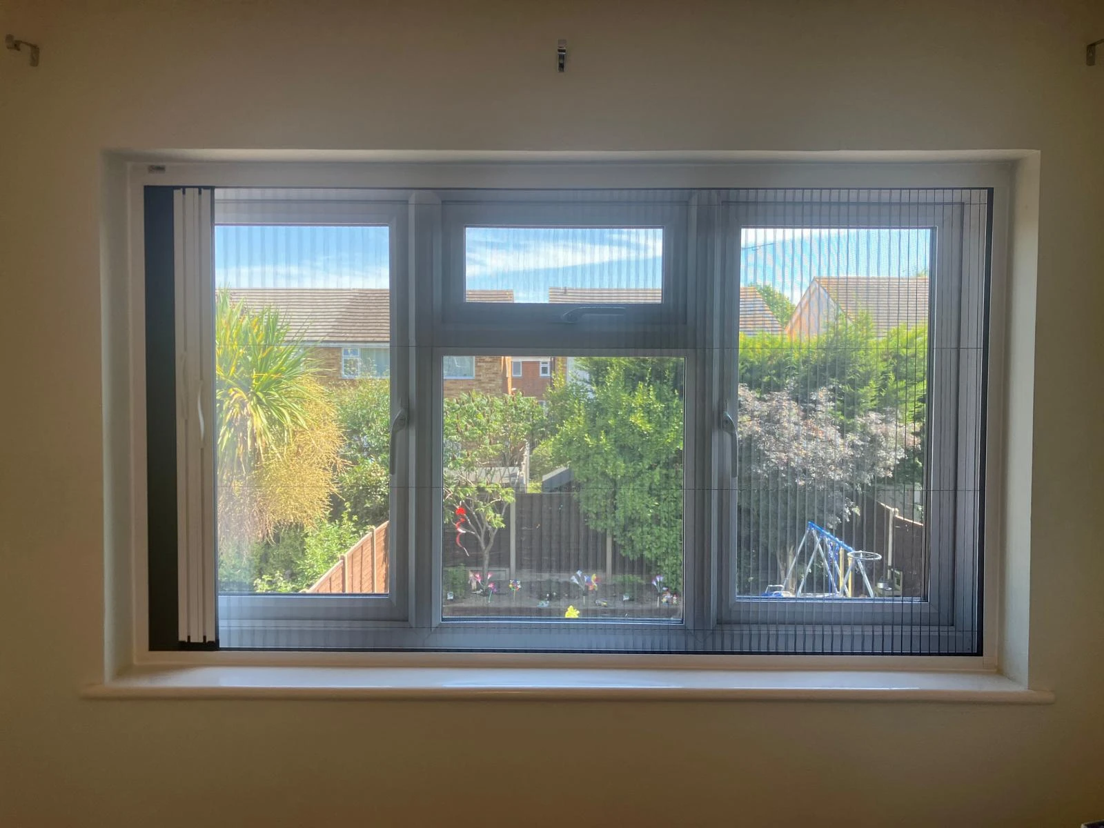Integrated Fly Screen installed within a modern window recess in an Essex home allowing ventilation and insect protection