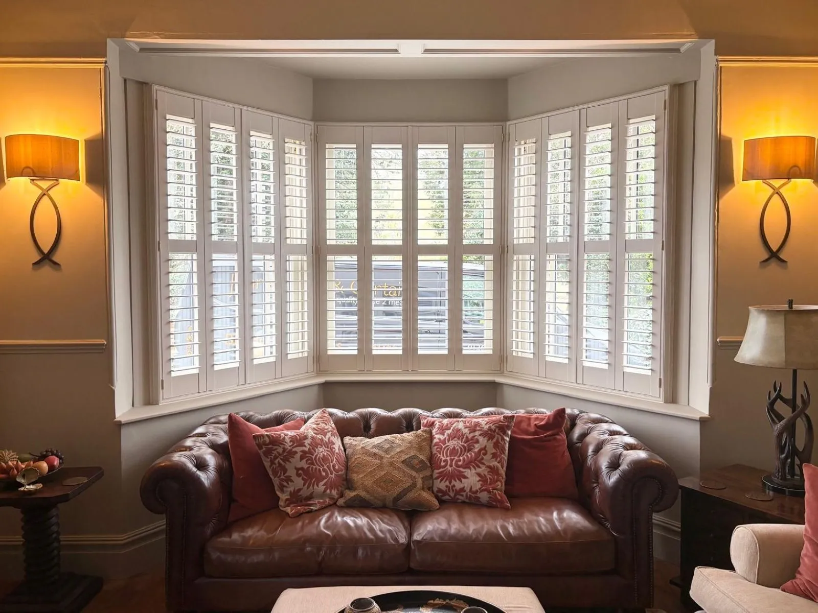 White plantation shutters fitted to a bay window, designed to follow each angle for a perfect made-to-measure fit