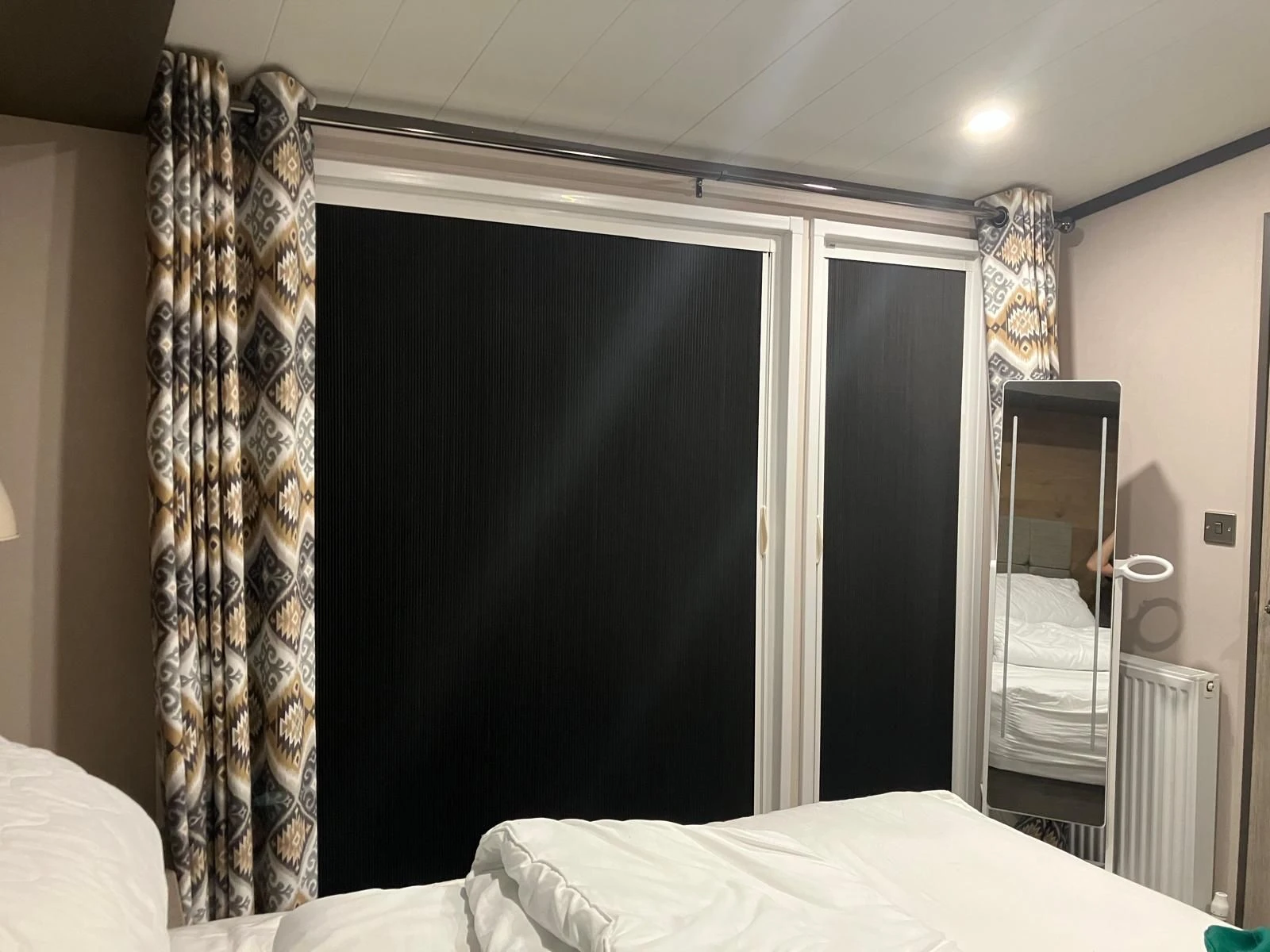 Blind Screen blackout system installed across bedroom doors and windows helping create a darker sleeping environment with reduced light leakage.