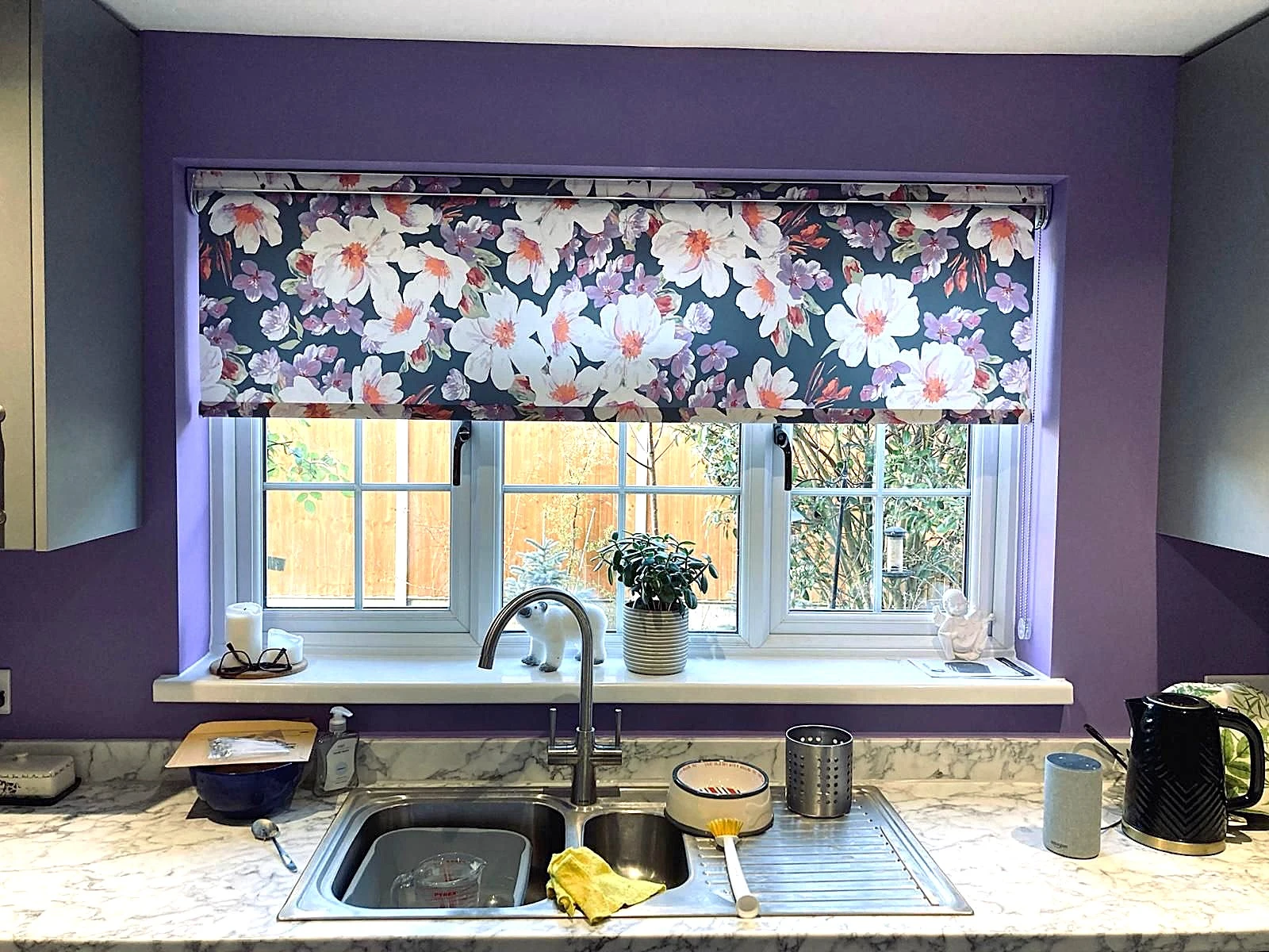 Floral patterned roller blind fitted within a modern kitchen in an Essex home.