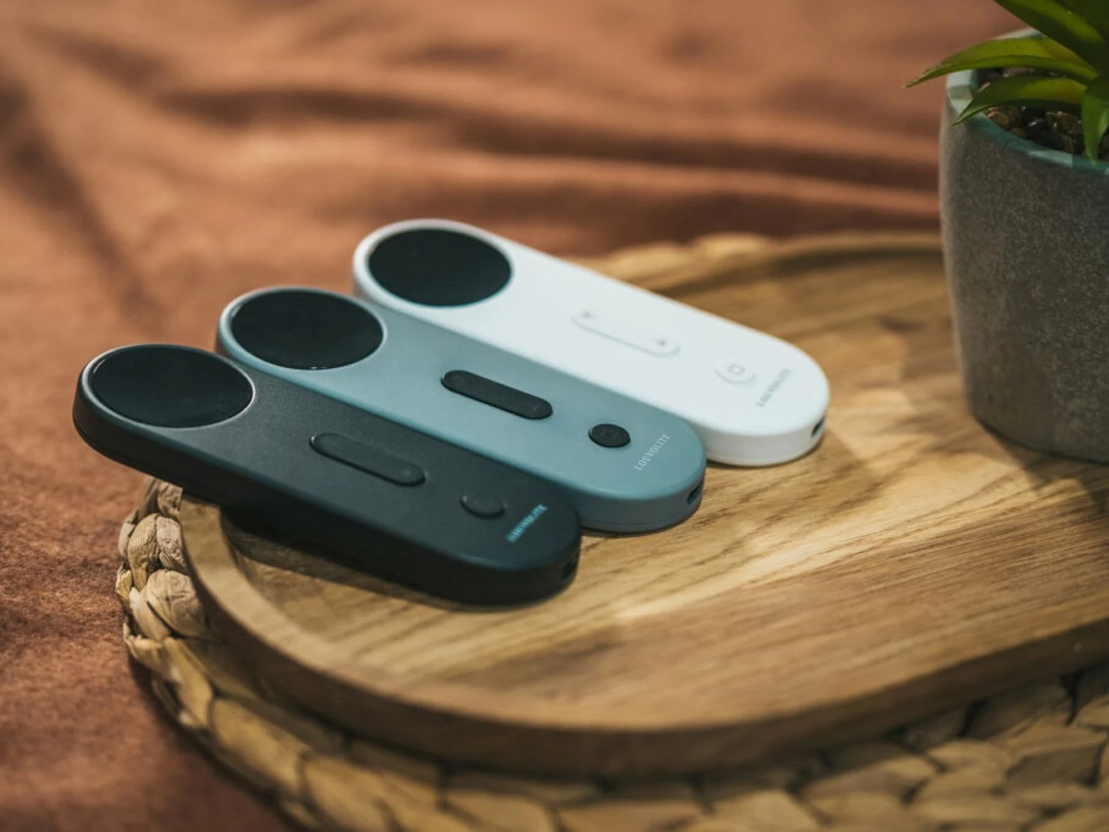 Smart Remote Controls for Automated Blinds Modern remote controls for automated blinds displayed on a wooden tray.