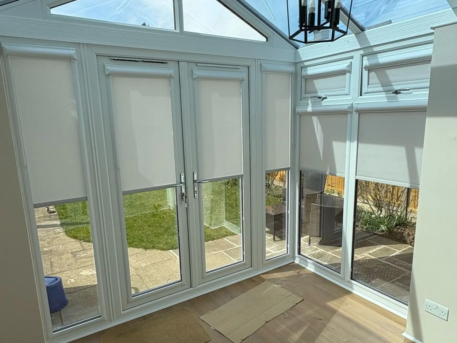 Cream fabric Perfect Fit Roller Blinds fitted to conservatory windows and French doors.