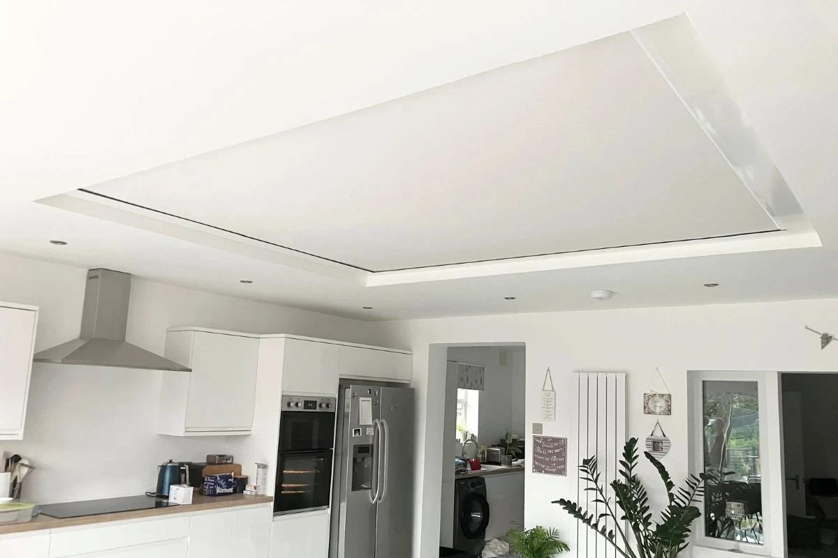 Made-to-measure roller roof lantern blind helping reduce heat and glare in a modern kitchen extension.