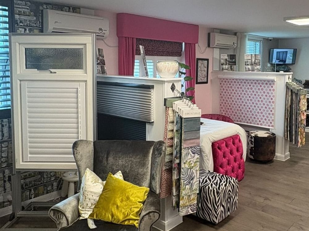 Interior of John’s Blinds & Curtains’ Wickford showroom with plantation shutters, blind displays, curtain fabrics and a bedroom display.